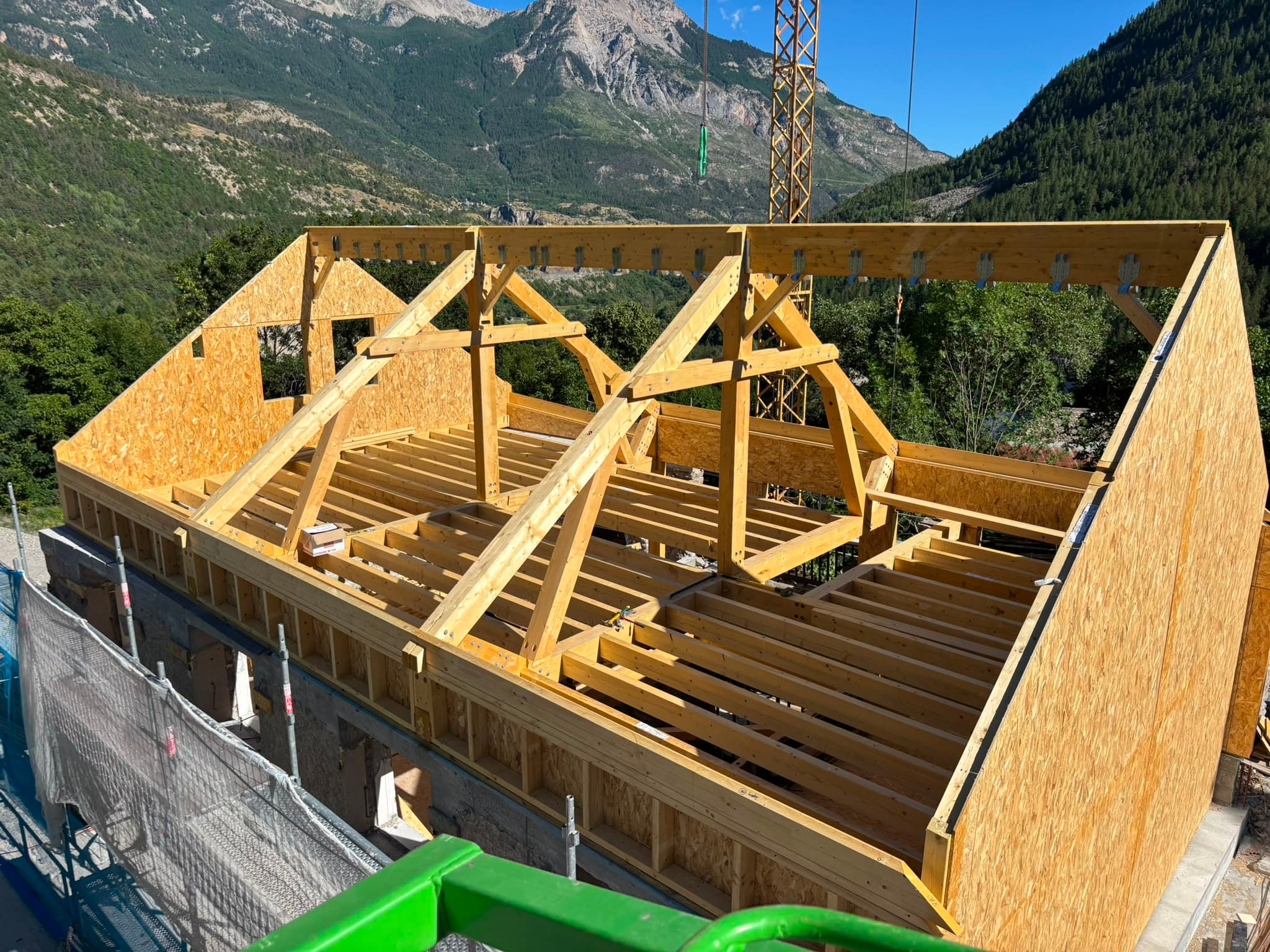 Charpente triangulée à fermes en bois, structure en cours de montage