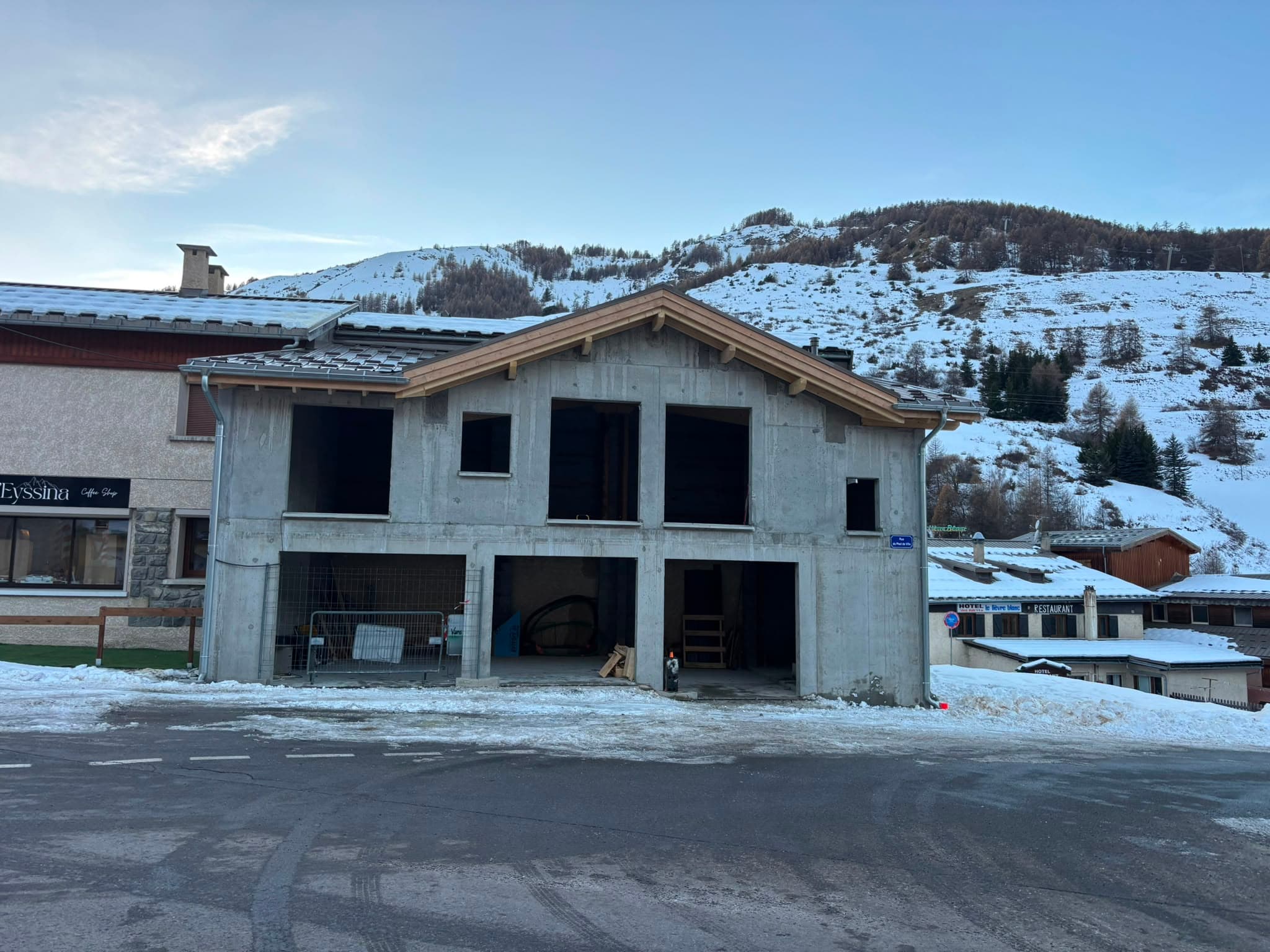 Construction neuve avec charpente et toiture posées, en hiver