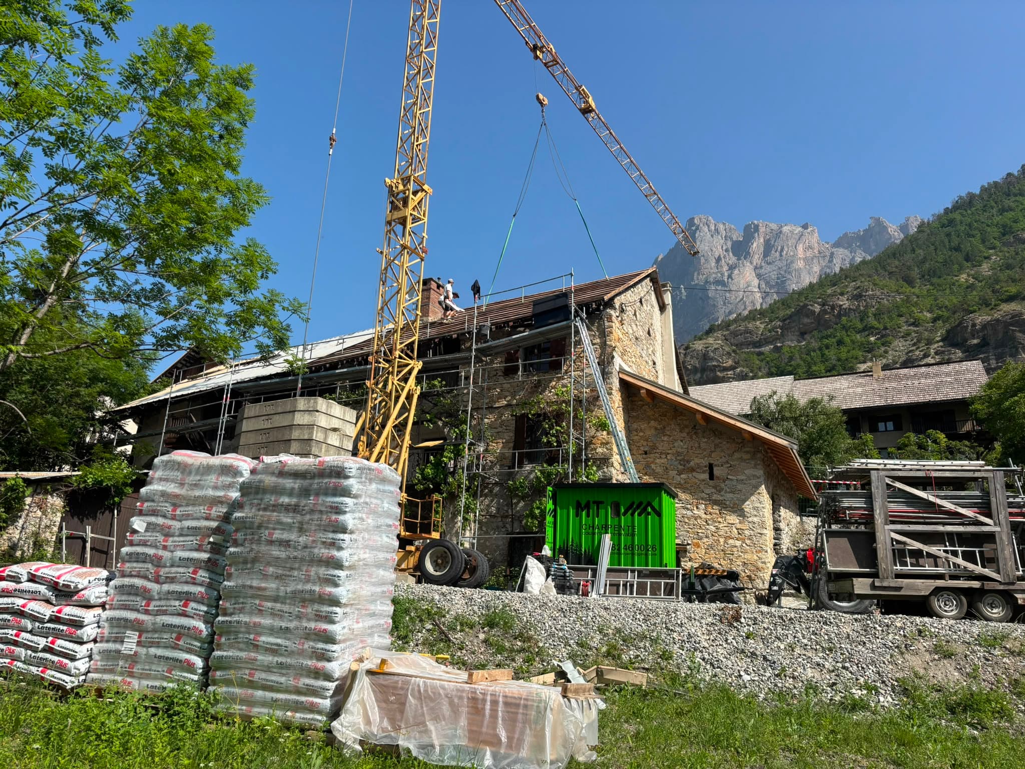 Rénovation de toiture d'une bâtisse ancienne avec échafaudage et grue